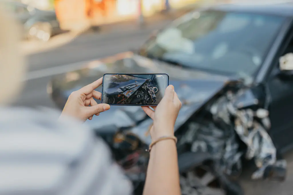 Siniestro vial. Hombre haciendo fotos del auto accidentado para presentar evidencias.