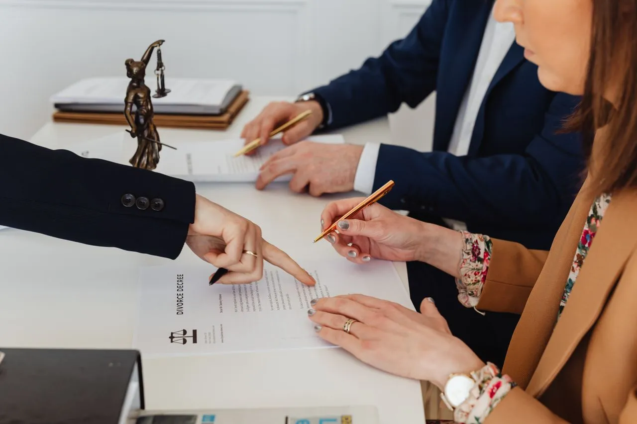 abogados-de-divorcio-negociación Pareja firmando acuerdo de divorcio ante Abogado